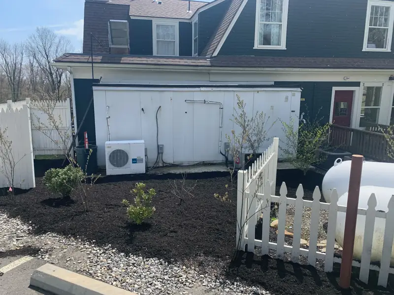 Fresh mulch beds behind a white picket fence