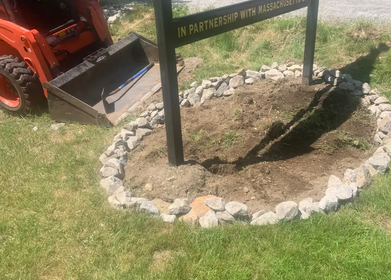 Stone ring installed around a sign with a skid steer