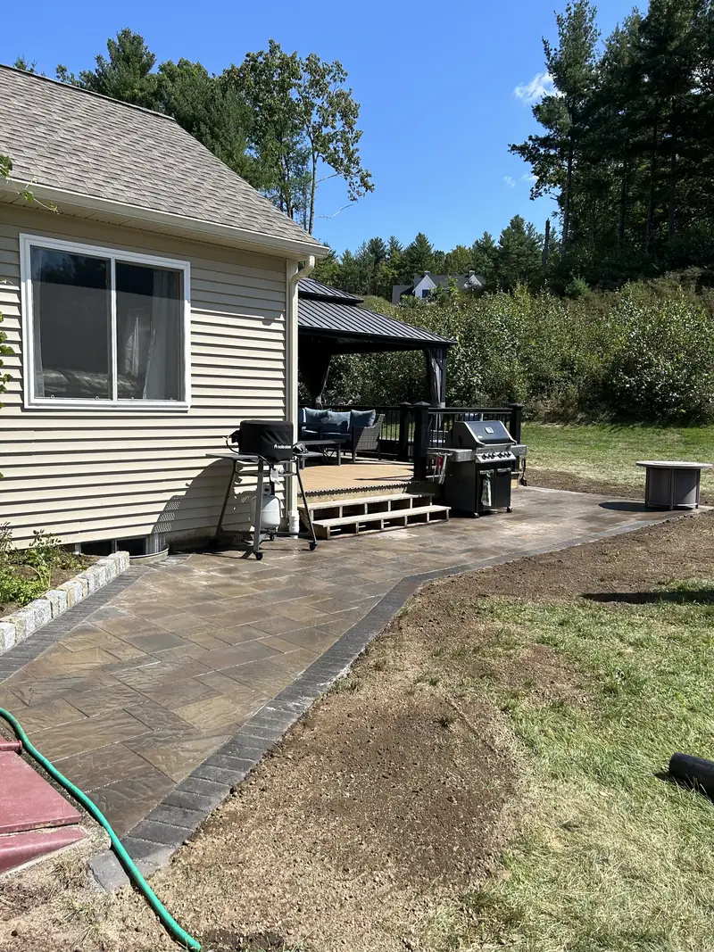 New paver patio beside a home's back steps