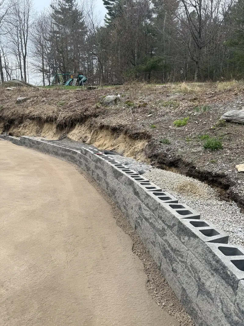 Retaining wall under construction along a driveway